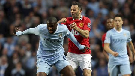 Giggs attempts to tussle against Toure in the derby